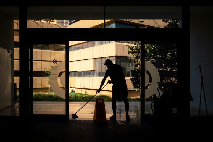 Person mopping a lobby floor by hand